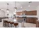 Beautiful kitchen with granite counters, stainless appliances, pendant lighting, and island seating at 40010 W Ganly Way, Maricopa, AZ 85138
