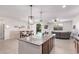 Open concept kitchen and living area offering modern island seating, stainless appliances and views of the pool at 40010 W Ganly Way, Maricopa, AZ 85138