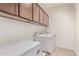 Laundry room with overhead storage cabinets and white front-loading washer and dryer units at 40010 W Ganly Way, Maricopa, AZ 85138