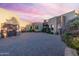 Beautiful exterior view of a custom home with a paver driveway and desert landscaping at sunset at 41667 N 113Th Pl, Scottsdale, AZ 85262