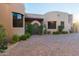 Exterior view of house with arched entry, desert landscaping, and paver driveway at 41667 N 113Th Pl, Scottsdale, AZ 85262