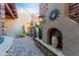 Charming front courtyard featuring a decorative fireplace, desert landscaping, and stone accents at 41667 N 113Th Pl, Scottsdale, AZ 85262