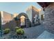 Inviting front courtyard with desert landscaping, stone accents, and an arched entry gate at 41667 N 113Th Pl, Scottsdale, AZ 85262
