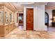 Hallway featuring travertine floors, display cabinet and wood door at 41667 N 113Th Pl, Scottsdale, AZ 85262