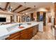 Open-concept kitchen featuring a large island with white countertop and wood cabinetry at 41667 N 113Th Pl, Scottsdale, AZ 85262