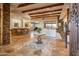 Spacious living room with stone accents, exposed beams, and access to an outdoor space at 41667 N 113Th Pl, Scottsdale, AZ 85262