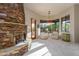 Bright living room with a stone fireplace and a window view of the outdoors at 41667 N 113Th Pl, Scottsdale, AZ 85262