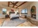 Spacious main bedroom with exposed wood beams, fireplace, and luxurious furnishings at 41667 N 113Th Pl, Scottsdale, AZ 85262