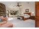 Large primary bedroom with stone fireplace, ceiling fan and a large window with seating at 41667 N 113Th Pl, Scottsdale, AZ 85262