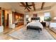 Comfortable main bedroom suite featuring a kitchenette, fireplace, and exposed wood beams at 41667 N 113Th Pl, Scottsdale, AZ 85262