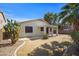 A home's backyard has a drought tolerant landscape with decorative rock, green lawn and covered patio at 43690 W Knauss Dr, Maricopa, AZ 85138