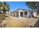 A home's backyard with decorative rock, green lawn and covered patio to enjoy outdoor living at 43690 W Knauss Dr, Maricopa, AZ 85138