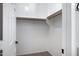 Bright walk-in closet with white walls, carpeted floor, and a wooden clothes rack at 43690 W Knauss Dr, Maricopa, AZ 85138