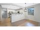 Eat in kitchen featuring stainless steel appliances, white cabinets and a breakfast bar at 43690 W Knauss Dr, Maricopa, AZ 85138