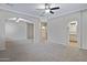 Open concept living room featuring a ceiling fan, arched doorways, and carpet at 43690 W Knauss Dr, Maricopa, AZ 85138