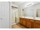 Bright bathroom with wood flooring, a double sink vanity and a shower stall at 45042 W Cypress Ln, Maricopa, AZ 85139