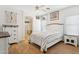 Cozy bedroom boasts light wood-look flooring, a ceiling fan, and access to the en suite bathroom at 45042 W Cypress Ln, Maricopa, AZ 85139