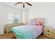 Bright bedroom with ceiling fan, wood-look flooring and colorful bedspread at 45042 W Cypress Ln, Maricopa, AZ 85139