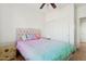 Bright bedroom with ceiling fan, wood-look flooring and colorful bedspread at 45042 W Cypress Ln, Maricopa, AZ 85139