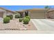 Inviting single-story home with a well-manicured, desert-landscaped front yard and neutral color palette at 45042 W Cypress Ln, Maricopa, AZ 85139