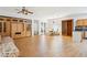 Spacious living room boasts wood-look flooring, a ceiling fan, and abundant natural light at 45042 W Cypress Ln, Maricopa, AZ 85139