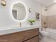 Stylish bathroom featuring modern vanity with illuminated mirror and bathtub with shower at 4532 E Sandra Ter, Phoenix, AZ 85032