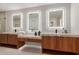 Bright bathroom featuring double sinks, wood cabinets and large lighted mirrors at 4532 E Sandra Ter, Phoenix, AZ 85032