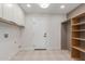 Clean laundry room with white cabinets, neutral paint and shelving for storage at 4532 E Sandra Ter, Phoenix, AZ 85032