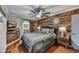 Cozy bedroom with wood accent wall, ceiling fan, and adjacent bathroom, creating a relaxing retreat at 4610 N 14Th Ave, Phoenix, AZ 85013