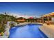 Stunning backyard with a sparkling pool, rock waterfall feature, and a fully-equipped outdoor kitchen at 4610 N 14Th Ave, Phoenix, AZ 85013