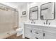 Modern bathroom featuring double sinks, stylish mirrors, and a walk-in shower with a glass door at 4700 S Fulton Ranch Blvd # 11, Chandler, AZ 85248