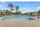 Community swimming pool with a sunning area, tables, chairs, and palm trees at 4700 S Fulton Ranch Blvd # 11, Chandler, AZ 85248