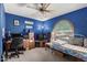 Cozy bedroom featuring blue walls, a ceiling fan, and a unique arched window with a comfortable daybed at 4957 W Onyx Ave, Glendale, AZ 85302