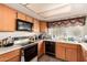 This kitchen features wood cabinets, black appliances and a sink at 4957 W Onyx Ave, Glendale, AZ 85302