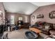 Spacious living room with a vaulted ceiling, brick fireplace, and neutral carpet at 4957 W Onyx Ave, Glendale, AZ 85302