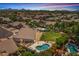 Expansive backyard featuring a sparkling pool and spa, lush landscaping, and mountain views at 6102 E Danbury Rd, Scottsdale, AZ 85254