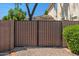 Wood backyard gate surrounded by greenery and brick at 6102 E Danbury Rd, Scottsdale, AZ 85254