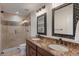 Bathroom featuring dual sinks, granite countertops and a glass enclosed tiled shower at 6102 E Danbury Rd, Scottsdale, AZ 85254