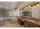 Luxurious bathroom with glass shower, soaking tub, double sinks, and granite counters at 6102 E Danbury Rd, Scottsdale, AZ 85254