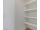 Walk-in closet featuring crisp white walls, and a system of shelves at 6102 E Danbury Rd, Scottsdale, AZ 85254