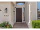 View of the front door with decorative sidelight, overhead window, and welcome mat at 6102 E Danbury Rd, Scottsdale, AZ 85254