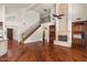 Open living room featuring fireplace, staircase with iron railing, and hardwood floors at 6102 E Danbury Rd, Scottsdale, AZ 85254