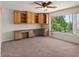 Bright office with built-in desk, cabinets, and large window overlooking landscaped yard at 6102 E Danbury Rd, Scottsdale, AZ 85254