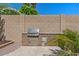 Built-in outdoor kitchen with grill, stainless steel appliances, and ample counter space at 6102 E Danbury Rd, Scottsdale, AZ 85254