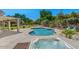 Scenic backyard with a sparkling pool, jacuzzi, covered patio, and lush landscaping at 6102 E Danbury Rd, Scottsdale, AZ 85254