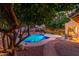 Inviting backyard pool featuring ambient lighting, lush greenery, and a serene outdoor dining area at 6918 W Villa Hermosa W --, Glendale, AZ 85310