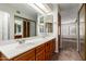 Bathroom featuring double sink vanity, large mirror, and ensuite access to closet and bedroom at 700 E Mesquite Cir # O210, Tempe, AZ 85288