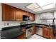 A view of the kitchen featuring stainless steel appliances, wood cabinets and black countertops at 700 E Mesquite Cir # O210, Tempe, AZ 85288
