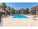 A community pool area surrounded by lounge chairs, palm trees, and buildings at 700 E Mesquite Cir # O210, Tempe, AZ 85288