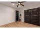 Bedroom featuring a modern ceiling fan, wood-look floors, closet with sliding doors and an open door at 720 E Chilton Dr, Tempe, AZ 85283